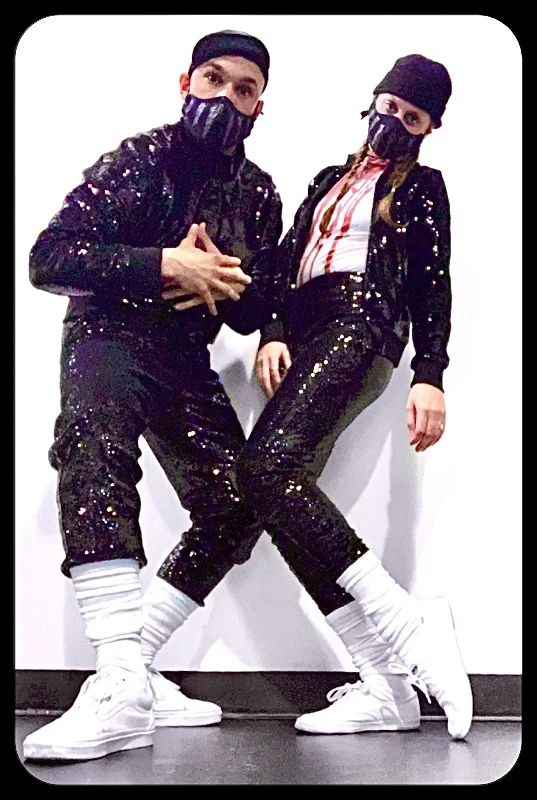 Two Undead performers in coordinated sequined costumes and patterned face masks, holding an angled full-body pose